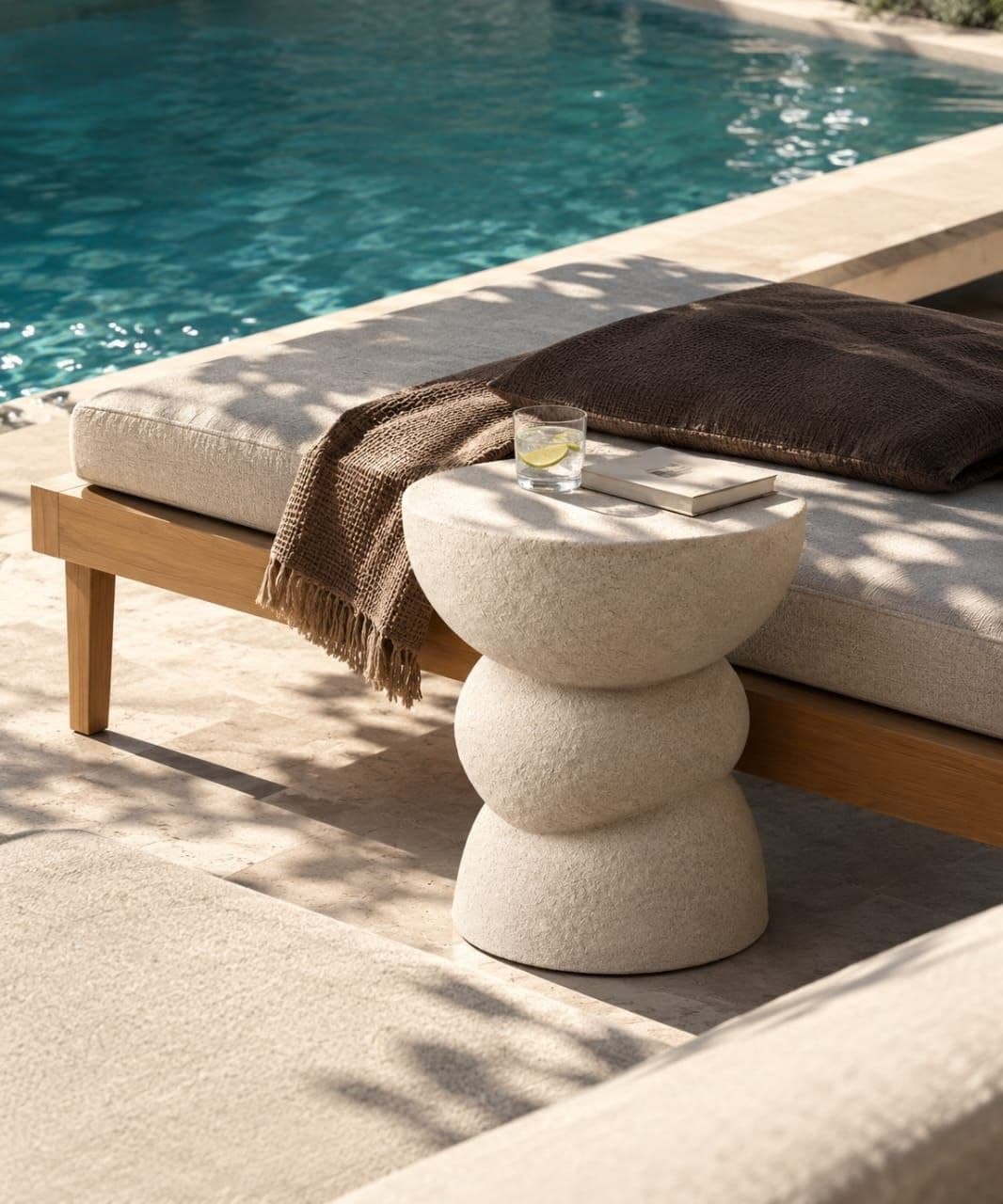 A stool-height side table pinched at the waist like a spinning top — two rounded volumes balanced on a narrow axis.